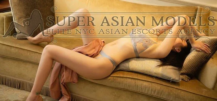 this sexy asian lady is lying on sofa with her legs in short skirt